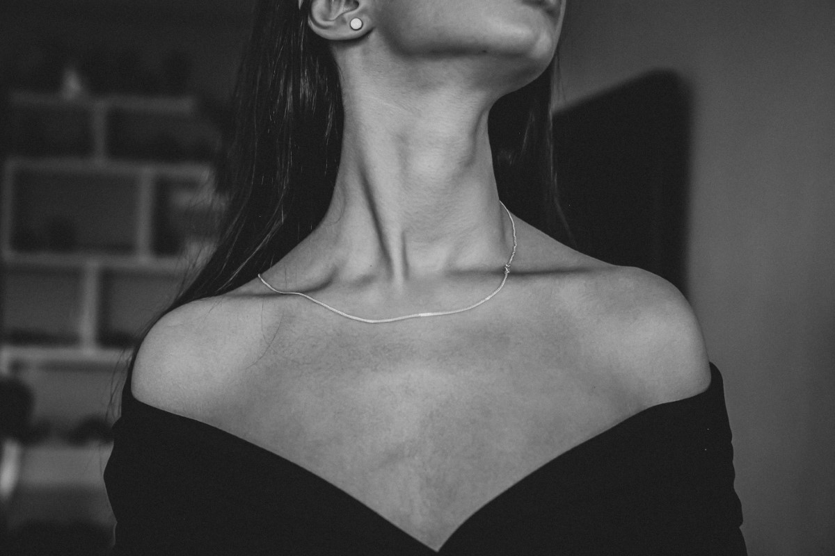 Mujer joven mostrando cuello con arrugas en blanco y negro