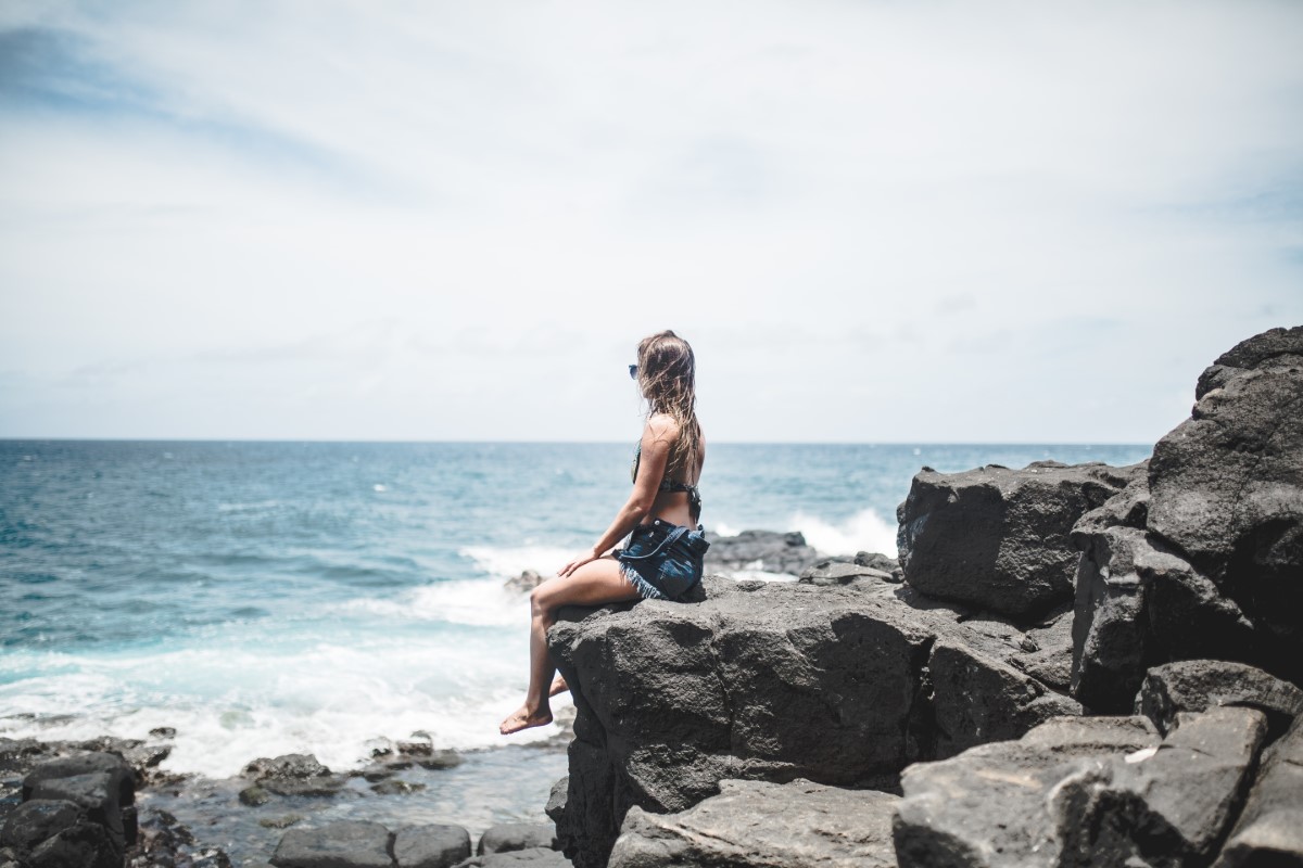 Mujer mirando al mar en la playa durante el verano