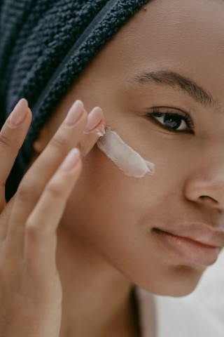 mujer aplicándose tratamiento para eliminar manchas en la cara